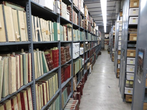 Looking down the main aisle of Archives South, our off-site storage building. The bound volumes are county clerk record books from across the state.