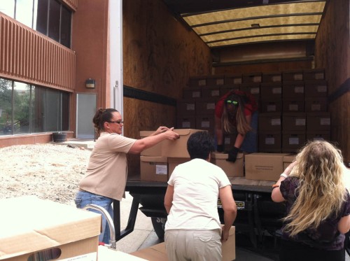 Records Analyst Lisa Hasting, in red, stacks boxes in the truck during a transfer trip stop in Casper this June.