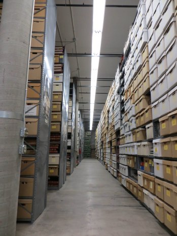 Looking down main aisle  of shelving at Archives South. The State Records Center is on the other side of the long wall to the right and looks very similar.