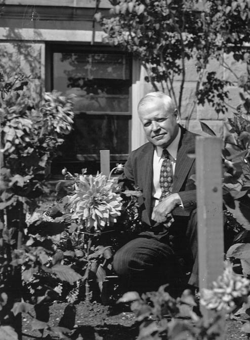Governor Miller was an avid gardener and daliahs were some of his favorites. Here he is with an 11 inch diameter specimen he planted outside the Capitol Building. August 21, 1938. (WSA P87-22/83)