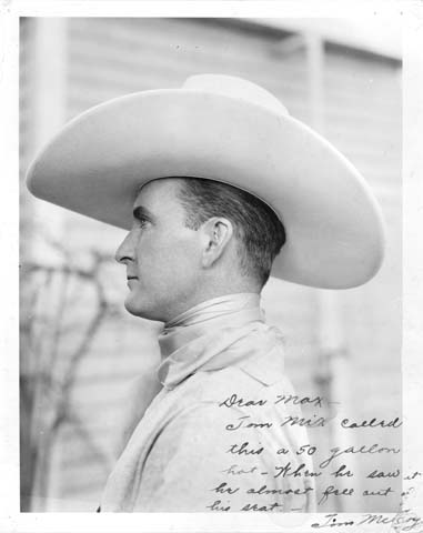 McCoy was well known for his very large hats and helped to popularize the "10-gallon" Stetson. Max Meyer, owner of a hat shop in Cheyenne, special ordered McCoy's hats and worked with the Stetson company to produce ever larger specimens. This photo was sent to Meyer in thanks. The inscription reads: "Dear Max - Tom Mix called this a 50 gallon hat. When he saw it he almost fell out of his seat. - Tim McCoy"